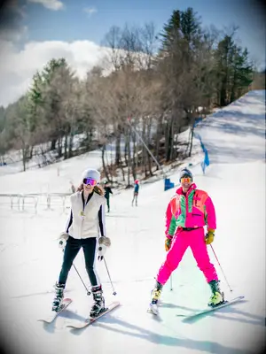 Bride and groom wearing white and pink retro snow suits.