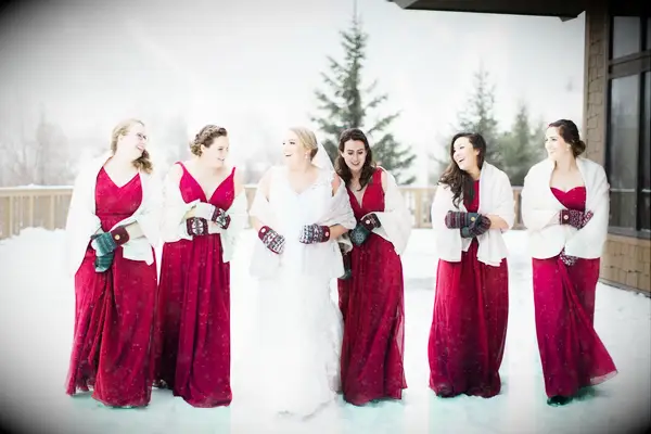 Bride and bridesmaids wearing red and grey mittens.