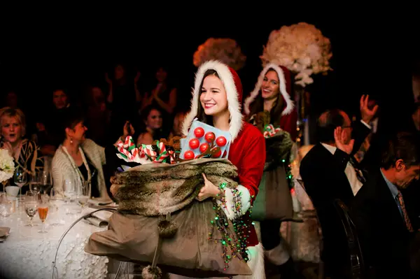 People wearing Christmas outfits and giving out wedding favors.
