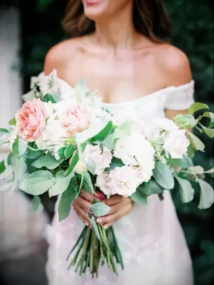 Woman carrying large flower bouquet with green leafs