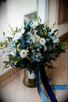 blue wedding bouquet with thistle, delphinium, white lisianthus and greenery