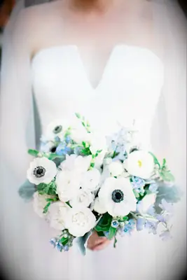white and light blue wedding bouquet with anemones, delphinium and roses