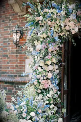 wedding venue doorway decorated with an arch of light blue and pink flowers