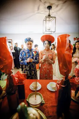 Couple praying at altar at Vietnamese wedding