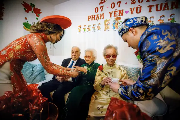 Couple serving tea to elders during Vietnamese wedding ceremony