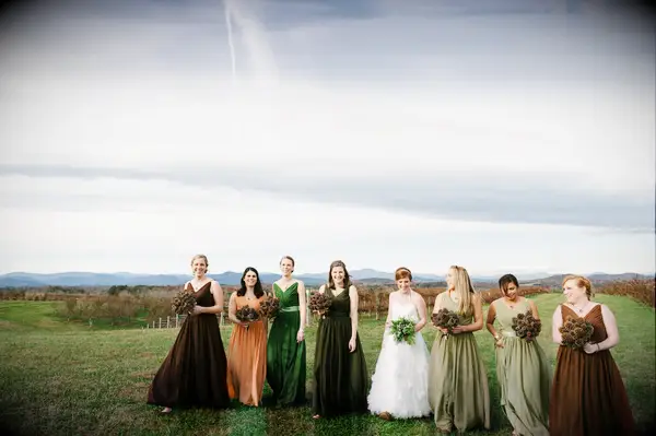 Bridesmaids standing in Field Wearing Earth Tone Dresses