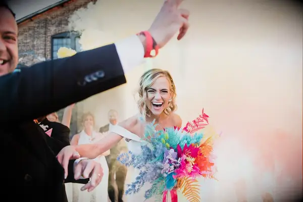Bride With Neon Bouquet of Dyed Flowers, Feathers Smiling Through Color Smoke