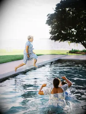 A Guest in Blue-and-White Dress Jumping into a Pool With Couple