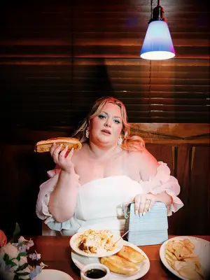 Bride Posing With Diner Food at Restaurant Elopement Party