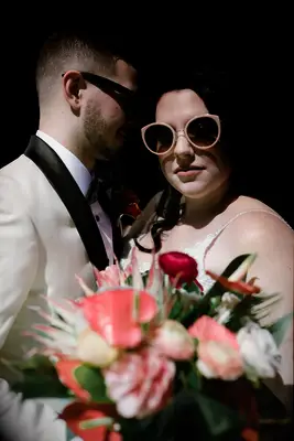 Chic and dramatic bride and groom wedding photos with floral bouquet