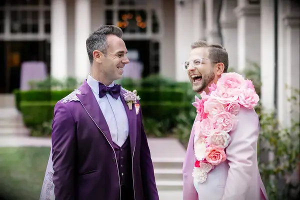Groom in Purple Tuxedo With Cape, Boutonniere and Groom in Pink Tux With Cascading Floral Lapel