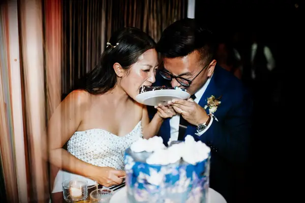 Bride and groom eating cake slice together