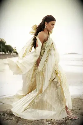 Bride in Flowing Gold Metallic Gown and Down Hairstyle on Rocky Beach