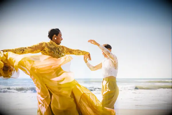 Couple dancing on the beach with coordinating yellow and lace outfits