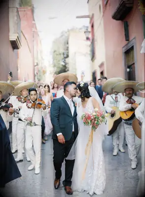 Couple kissing in the street during La Callejoneada Mexican Wedding Parade