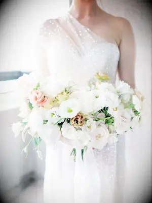 Bride in white dress with all-white bouquet
