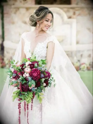 Bride holding cascading burgundy bouquet