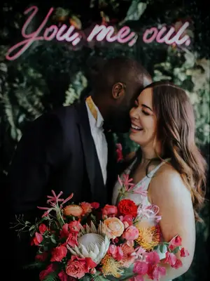 Couple laughing and holding pink bouquet