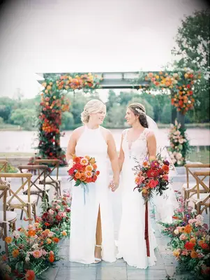 Two brides holding red bouquets