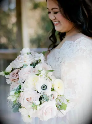 Bride holding bouquet with white, pink and gray flowers