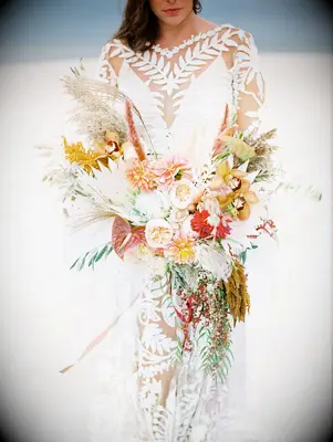 Bride holding boho bouquet on the beach