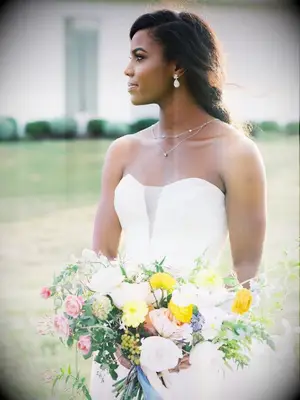 Bride holding yellow wildflower-inspired bouquet