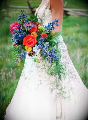bride holding red bouquet with cascading greenery