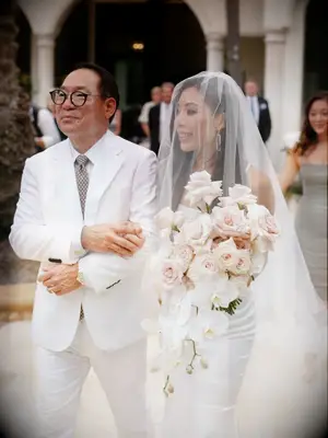 Bride holding bouquet and processing with father