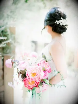 bride holding coral charm peony bouquet