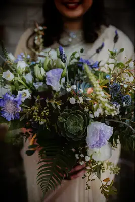 boho wedding bouquet with succulents, ferns, blue thistle, purple scabiosa, lisianthus and lavender