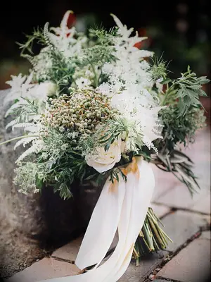 greenery wedding bouquet with white astilbe, white roses, thistle and white ribbons