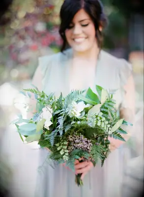 bridesmaid holding greenery bouquet with plumosa ferns, maidenhair ferns, lemon leaves, berries and white flowers