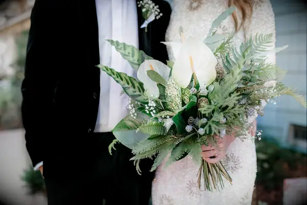 tropical greenery wedding bouquet with ferns, white anthuriums and banana leaves