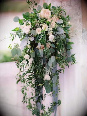 romantic cascading greenery wedding bouquet with vines, silver dollar eucalyptus, ivory roses and long pale blue ribbons