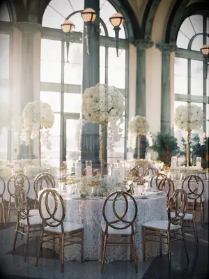 Elegant baroque wedding centerpieces with tall white florals and antique gold vases