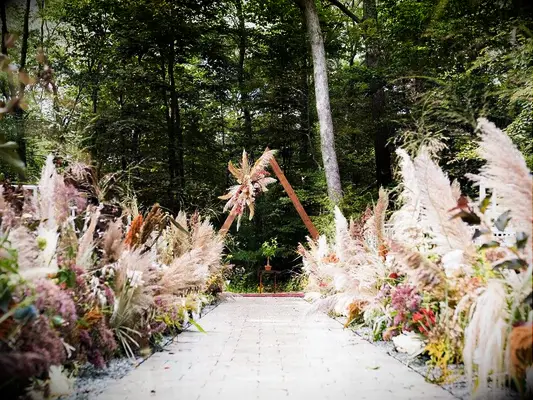 Lush pampas grass arrangements along outdoor wedding ceremony aisle and at altar