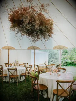 Neutral statement floral chandelier hanging from wedding tent