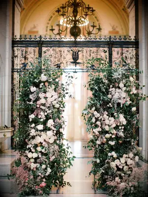 Dramatic lush floral bushes at wedding entrance
