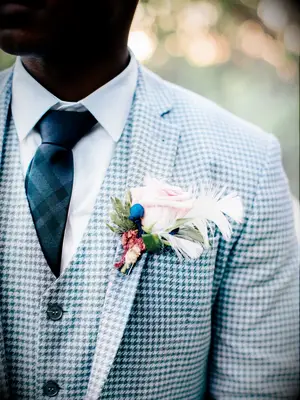 Groom wearing pastel pink floral boutonniere and blue houndstooth suit