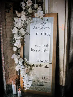 Mirrored wedding signage with white floral garland decoration