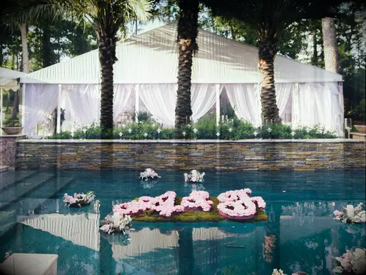 Outdoor wedding with floating floral monogram in pool