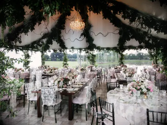 Garland-draped ceiling of outdoor wedding tent