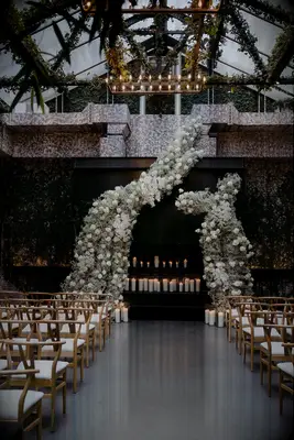 Elegant Ceremony Altar With Asymmetrical White Floral Structure Backdrop, Candles, Greenery