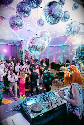 Wedding reception decorated with disco balls and bright blue and purple uplighting