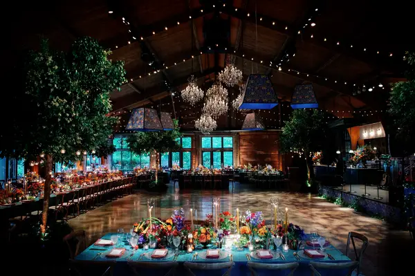 Jewel-tone wedding reception decor with amber uplighting