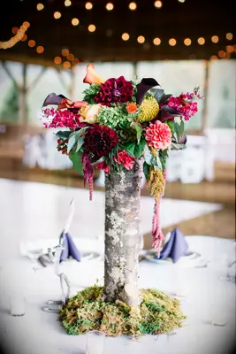 rustic fall wedding centerpiece with red, pink and yellow flowers in wooden vase