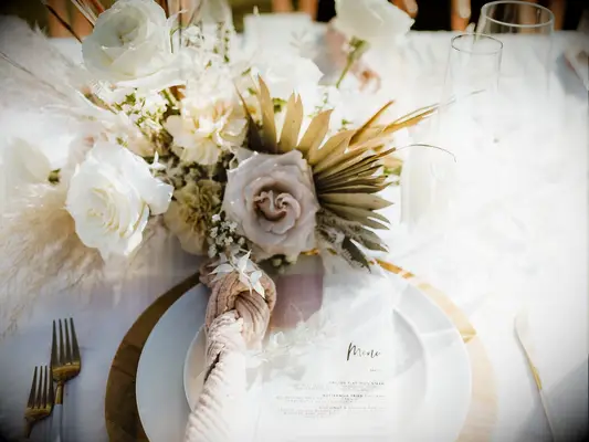 beachy fall wedding centerpiece with blush and white roses and dried fan palm
