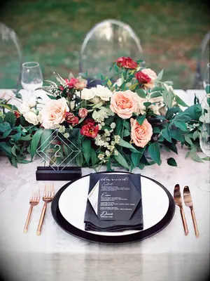 low fall wedding centerpiece with pink roses, greenery and acrylic square table numbers