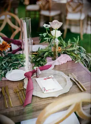 romantic fall wedding centerpiece with blush taper candle and greenery branches on wooden table