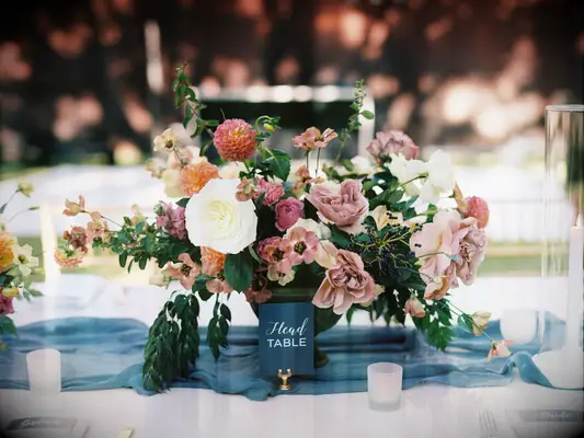 fall wedding centerpiece with mauve garden roses, pink dahlias, greenery and blue gauze table runner